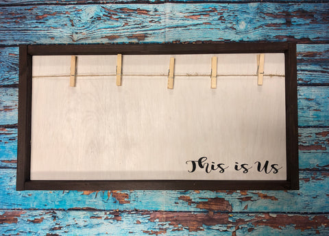This is us custom wooden sign intended to hold photo with clothespins.  Comes with 5 pins, but could hold more.